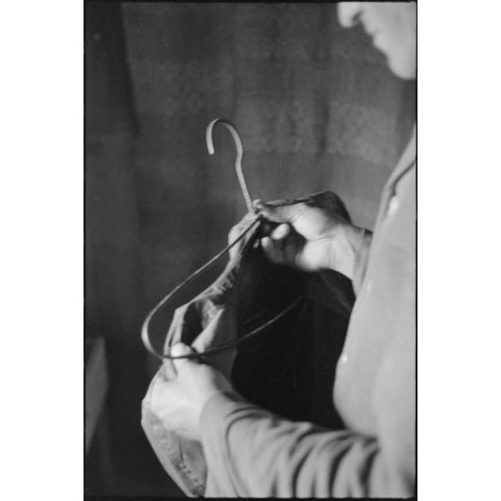 Dans un abri de campagne, la vie quotidienne de fantassins de la 205. Infanterie-Division (rangement d'un uniforme).