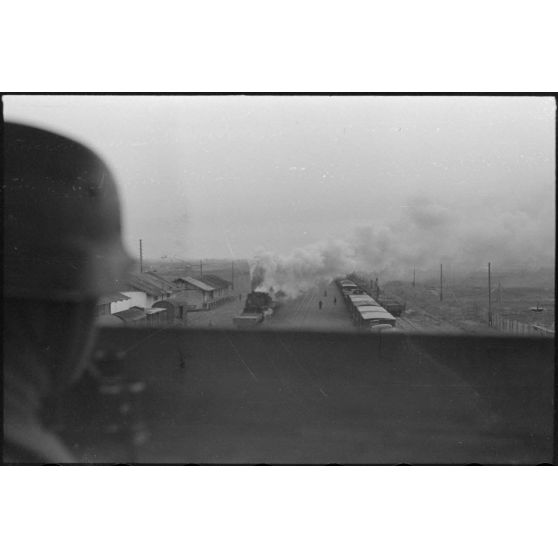 Des trains allemands vus depuis un mirador dominant une gare de moyenne taille.