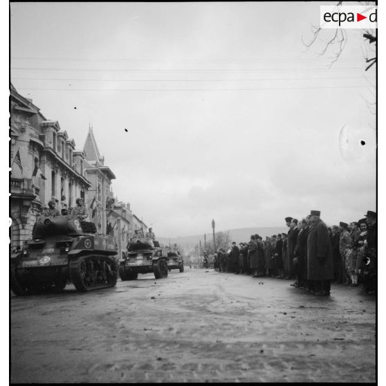 Défilé d'obusiers M8 du 2e RCA lors d'une cérémonie (à Vesoul ?) avec la 1re DB à l'occasion de la commémoration du 11 Novembre.