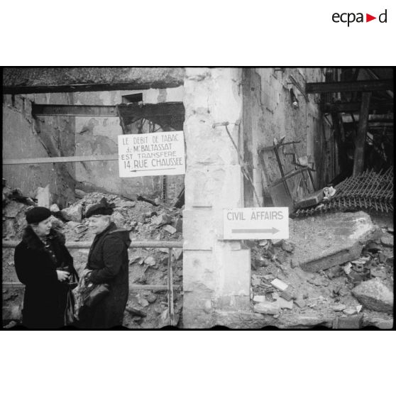 Habitantes dans une rue de Metz endommagée lors des combats de libération de la ville entre le 20 et 22 novembre 1944 par le 20e Corps d'armée américain.
