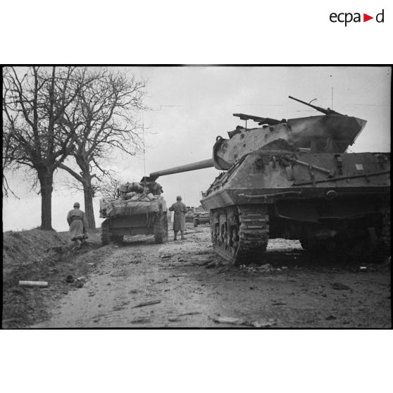 Colonne motorisée composée de blindés et d'half-tracks de la 1re armée française progressant sur une route boueuse en direction de Heimsbrunn et menant une offensive pour reconquérir la ville.