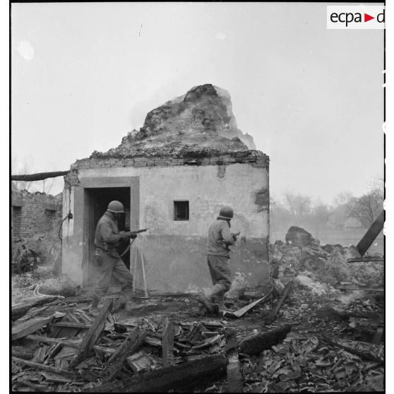 Fantassins du CC4 (Combat command n°4) de la 5e DB, armés de fusils, à l'assaut de la commune de Dannemarie (Haut-Rhin) en ruine.