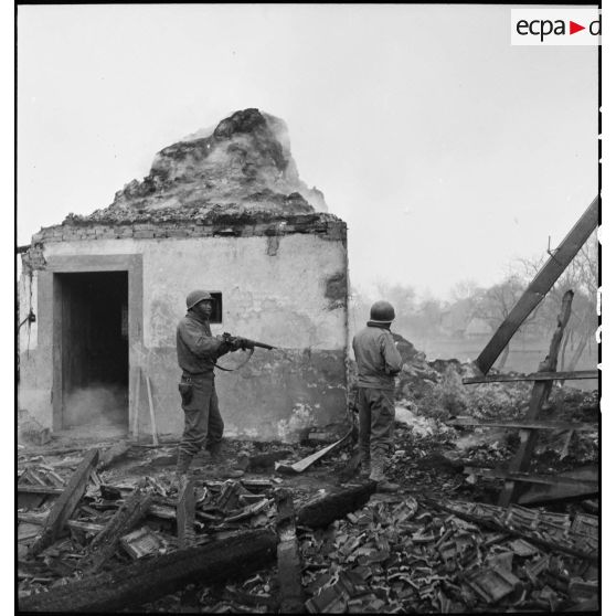 Fantassins du CC4 (Combat command n°4) de la 5e DB, armés de fusils, à l'assaut de la commune de Dannemarie (Haut-Rhin) en ruine.