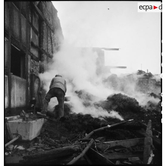 Habitant de Dannemarie, tentant d'éteindre un incendie provoqué par les combats menés par la 5e DB (division blindée) pour reconquérir la commune.