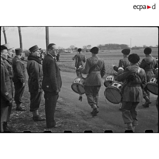 La musique militaire de la 10e DI (division d'infanterie) défile devant André Diethelm, le général Billotte et le général Revers.