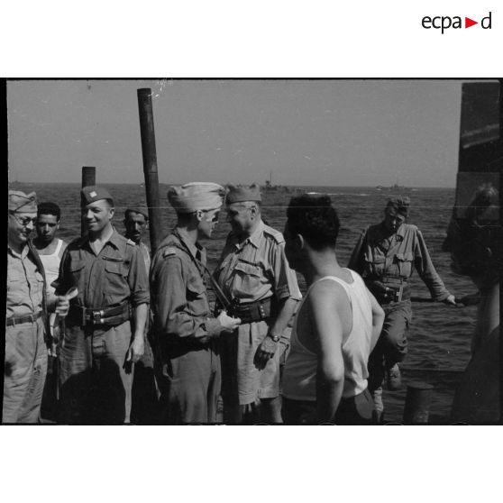 Partis de Naples, des officiers français et américains du 1er Corps d'armée à bord d'un transport de troupes font route pour la France en vue du débarquement allié sur les côtes de Provence (opération Anvil-Dragoon) en août 1944.