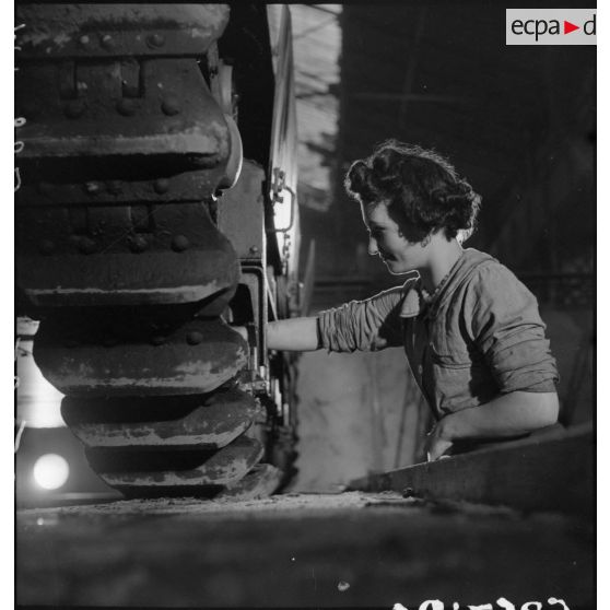 A l'atelier d'Issy-les-Moulineaux, une ouvrière travaille sur le train de roulement d'un char Renault R40.