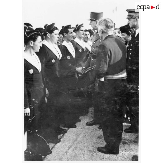 Lors de la cérémonie de remise de la Croix de la Libération à l'Ile de Sein, des marins ayant rallié les FNFL (forces navales françaises libres) sont présentés au général de Gaulle.
