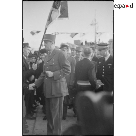 Le général de Gaulle salue des anciens combattants lors de la cérémonie de remise de la Croix de la Libération aux Sénans.