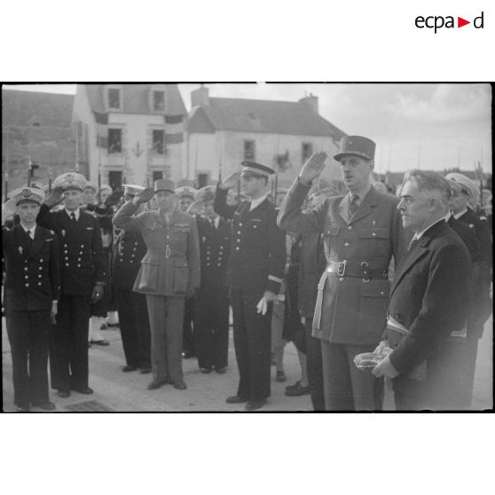 Les autorités militaires saluent pendant l'exécution de la Marseillaise, à l'issue de la cérémonie de remise de la Croix de la Libération au maire de l'Ile de Sein par le général de Gaulle.