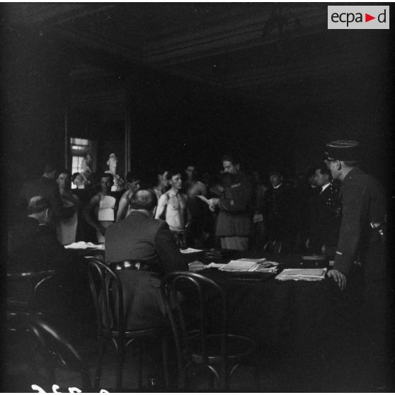 Des citoyens polonais nus passent devant des officiers français de la 1re armée pour le conseil de révision.