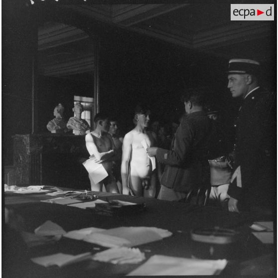 Des citoyens polonais nus passent devant des officiers français de la 1re armée pour le conseil de révision.