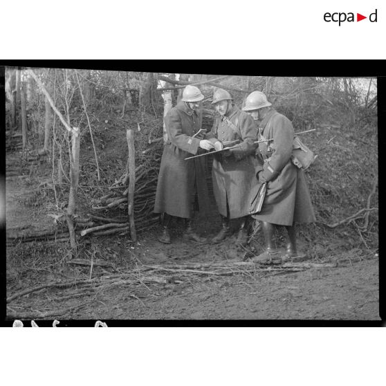 Photographie de groupe d'officiers du 142e RA qui regardent une carte.
