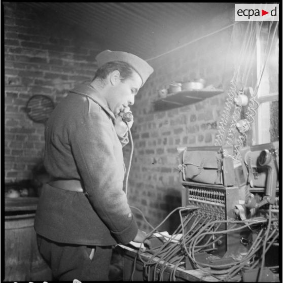 Un sergent du 404e RAAA utilise un téléphone de campagne à l'intérieur du poste de commandement.