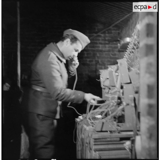 Un sergent du 404e RAAA utilise un téléphone de campagne à l'intérieur du poste de commandement.