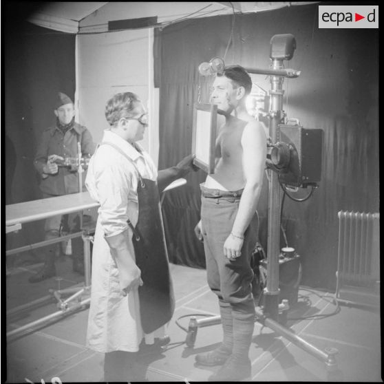 A l'infirmerie de l'hôpital un infirmier fait passer une radio à un soldat.