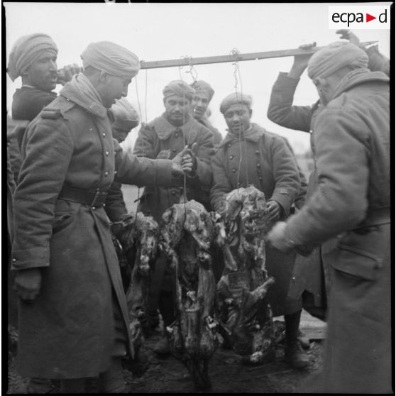 Des tirailleurs du 4e RTM préparent des carcasses de moutons pour le méchoui.