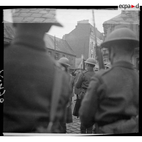 Des troupes écossaises de la BEF sont photographiées de dos en plan moyen lors d'une cérémonie militaire.