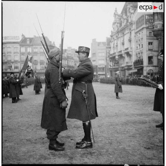 Le général de brigade Dame décore un tirailleur de la 2e DINA.