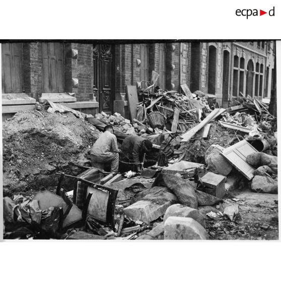 Plan général d'ouvriers qui travaillent dans une rue de Valenciennes transformées en champ de ruines.