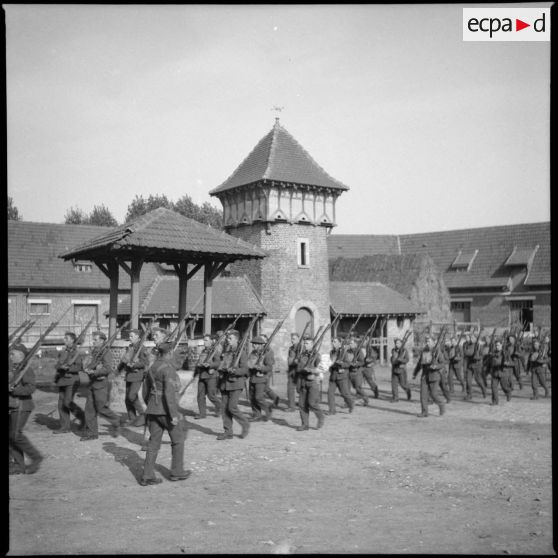Plan général de soldats de la BEF (British expeditionary force) qui font de l'ordre serré dans une cour de ferme.