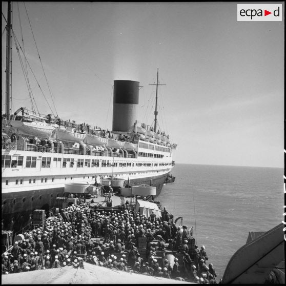 A bord du LST (landing ship tank) Orne, des légionnaires du 5e REI (régiment étranger d'infanterie) et 1e REC (régiment étranger de cavalerie) rejoignent le Pasteur pour quitter l'Indochine.