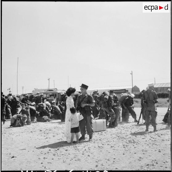 Sur les quais, un légionnaire dit au revoir à une femme vietnamienne et à une enfant avant de quitter l'Indochine.