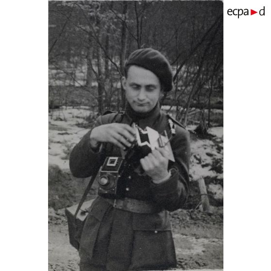 [Portrait d'un photographe du SCA (Service cinématographique de l'armée) manipulant ses appareils, s.d.]