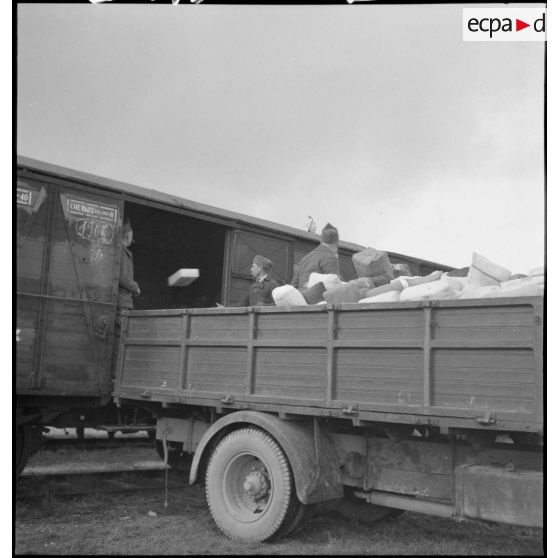 Des soldats de la 2e armée transbordent des colis d'un wagon de chemin de fer à la caisse d'un camion.