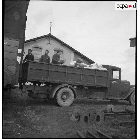 Des soldats de la 2e armée transbordent des colis d'un wagon de chemin de fer à la caisse d'un camion.