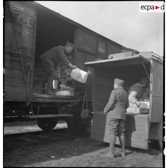 Des soldats de la 2e armée transbordent des colis d'un wagon de chemin de fer à la caisse d'un camion.