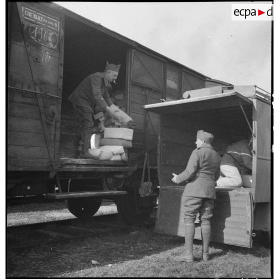 Des soldats de la 2e armée transbordent des colis d'un wagon de chemin de fer à la caisse d'un camion.