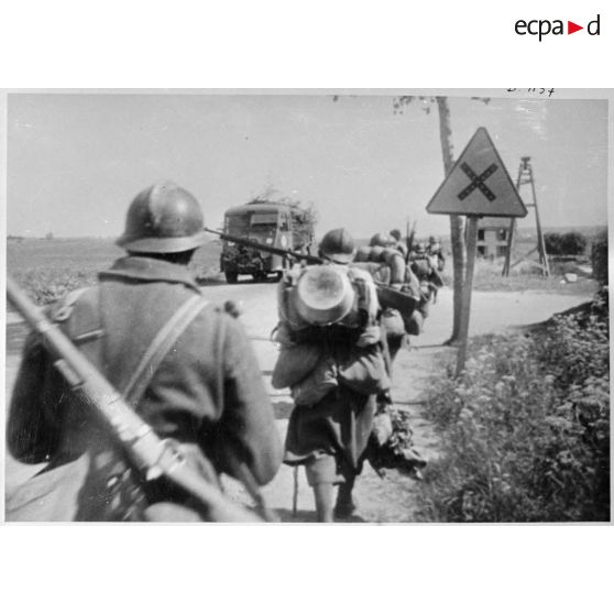 Une colonne d'infanterie de la 2e armée qui marche au bord d'une route croise un camion Renault.