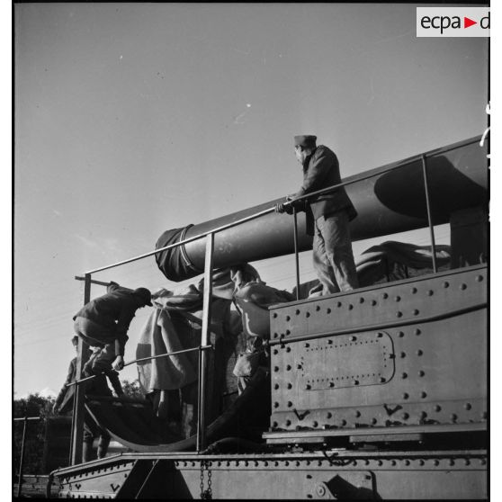 Des artilleurs de l'ALVF enlèvent les toiles de camouflage à l'avant d'une pièce de 340 mm à glissement modèle 1912.
