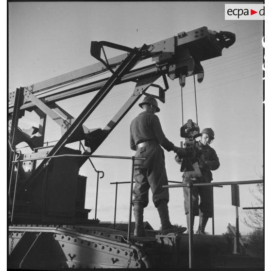 Deux artilleurs manipulent la grue portique d'une pièce de 340 mm à glissement modèle 1912 de l'ALVF.