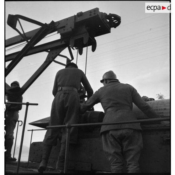 Deux artilleurs manipulent un obus grâce à la grue portique d'une pièce de 340 mm modèle 1912 de l'ALVF.