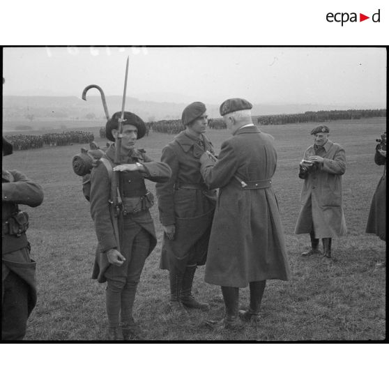 Le général d'armée Bourret, commandant la 5e armée, décore un chasseur alpin de la 28e DIA.