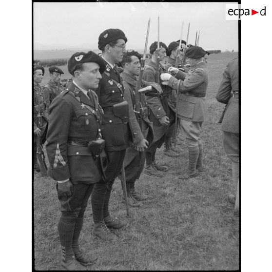 Le général de division Lestien décore des chasseurs alpins de la 28e DIA qu'il commande.