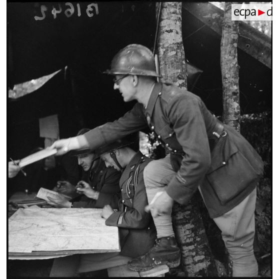 Photographie de groupe d'un lieutenant et d'un capitaine dans le PC d'une batterie du 24e RA dans la région de Montmédy.