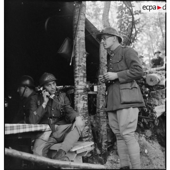 Photographie de groupe d'un lieutenant et d'un capitaine dans le PC d'une batterie du 24e RA dans la région de Montmédy.
