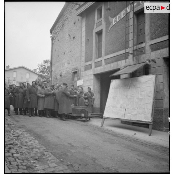 Des soldats de la 2e armée attendent devant un cinéma une séance du cinéma aux armées.