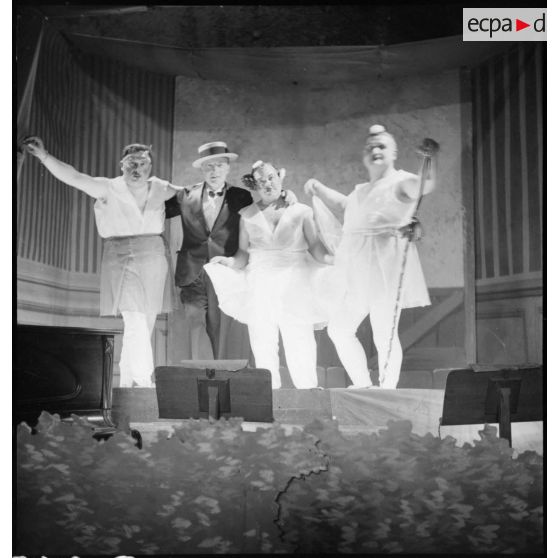 Sur une scène, photographie de groupe de comédiens lors d'une représentation du théâtre aux armées.