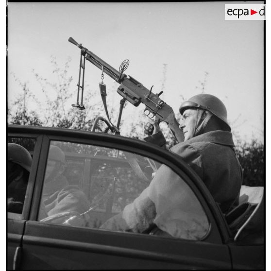 Plan moyen de profil d'un soldat du 3e escadron du 17e GRCA qui sert un FM M24/29 monté sur un affût antiaérien.