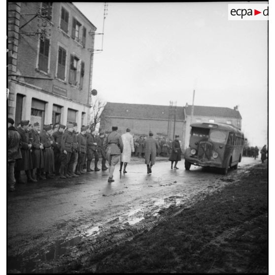 Plan général de permissionnaires de la 2e armée qui attendent au bord d'une rue.