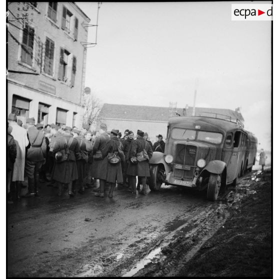 Plan général de permissionnaires de la 2e armée qui attendent au bord d'une rue.