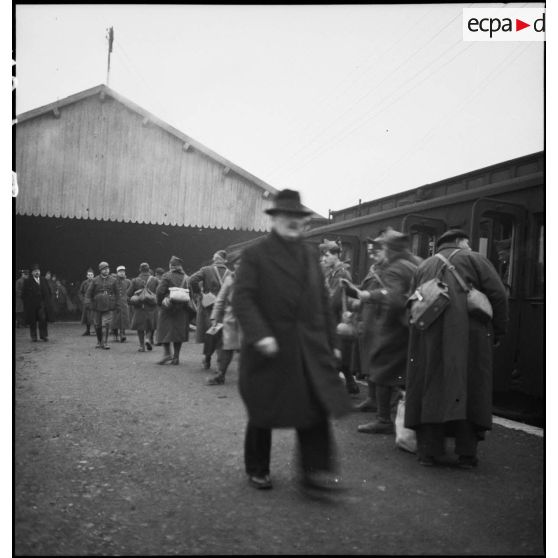 Plan général de permissionnaires de la 2e armée qui attendent près d'une gare ferroviaire.