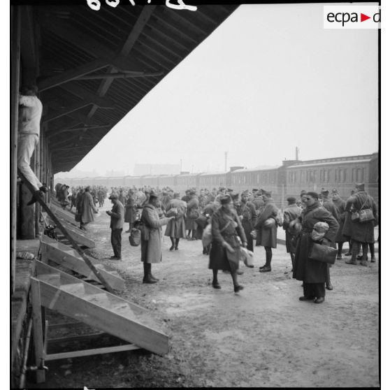 Plan général de permissionnaires de la 2e armée qui attendent près d'une gare ferroviaire.