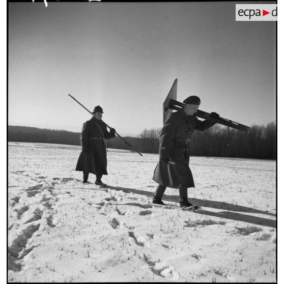 Dans un paysage enneigé, des lieutenants artilleurs de la 2e armée effectuent des relevés topographiques.