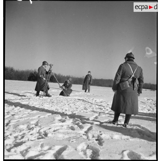 Dans un paysage enneigé, des lieutenants artilleurs de la 2e armée effectuent des relevés topographiques.