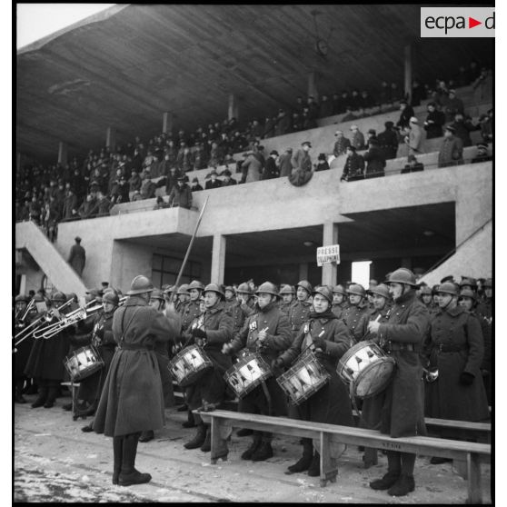 Musique militaire exécutant les hymnes nationaux avant une rencontre amicale de football.